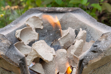Burning black charcoal in the old stove with paper and dry wood. It produces a lot of smoke when it burns.