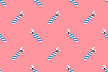 Adjustable wrench seamless pattern. Background made of a metal adjustable wrench with a rubber striped handle. 