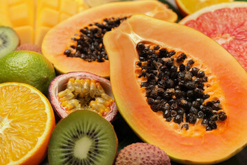 Fresh ripe papaya and other fruits as background, closeup