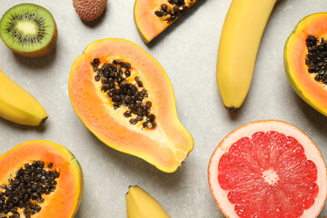 Fresh ripe papaya and other fruits on light grey table, flat lay
