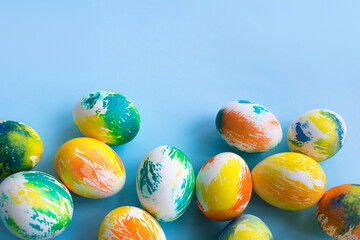 Top view of multicolored Easter eggs on a blue background. Happy Easter card. Dyed Easter eggs. Copy space for your text. Flat lay style. Top view. 