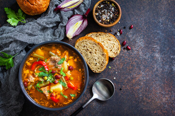 Homemade Meat Tomato soup with beef and bean stew, vegetables on a stone tabletop. Top view flat lay. Copy space.