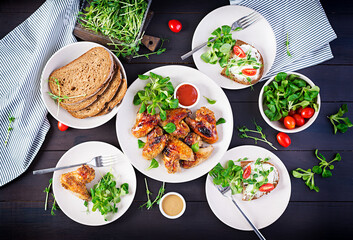 Grilled chicken wings. Baked chicken wings on wooden table. Table setting. Top view, flat lay, overhead