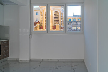 Inside view of the renovated, freshly painted room looking to the windows