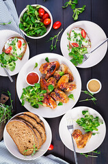 Grilled chicken wings. Baked chicken wings on wooden table. Table setting. Top view, flat lay, overhead