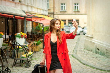 Beautiful young caucasian tourist woman takes a selfie in a European city