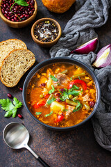 Homemade Meat Tomato soup with beef and bean stew, vegetables on a stone tabletop. Copy space.