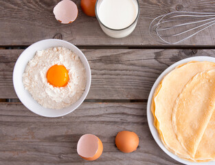 Flat composition with thin pancakes on wooden background. Ingredients