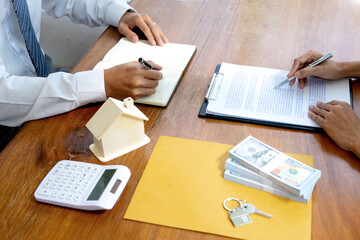 Businessmen and clients are reading and signing contracts for buying or renting a house