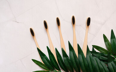 Ecological toothbrushes made of natural bamboo for the whole family on a white marbled background. Zero waste concept. Sustainable lifestyle. The concept of a future without plastic. copy space. 