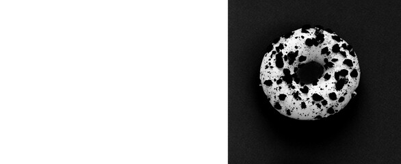 Creative mockup of a white donut with powder on a black and white background. Flat lay. Food concept. Macro concept