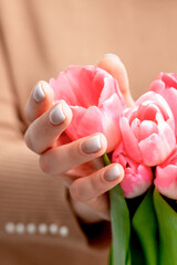 Closeup of pink tulip buds in hands of a young woman. Pink flowers in female hands