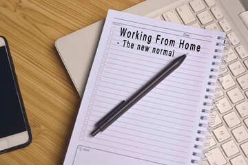 Text on notepad with laptop and smartphone