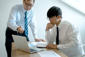 Fototapeta premium A businessman mentor stand and intern staff sit consultant