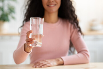 Healthy Drink. Unrecognizable Smiling Lady Offering Glass With Mineral Water At Camera