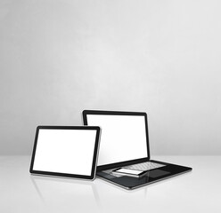 Laptop, mobile phone and digital tablet pc on white concrete office desk