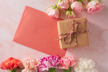 Mother's day concept. Pink rose, carnation, giftbox and letter.