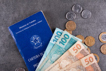 Brazilian work card with real bills and coins