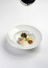 michelin star chef is decorating conceptual cuisine plate with sauce