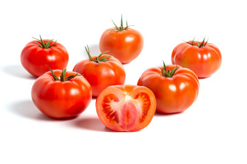 a group of tomatoes on a white background, with shadows. One tomato cut, studio photo, isolate, tomatoes washed