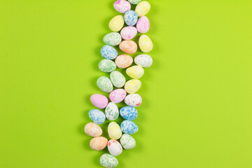 Flat lay composition of Happy Easter holiday concept. Colorful pastel egg on green background. top view