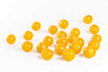 multiple yellow cherry tomatoes on a white background with shadow