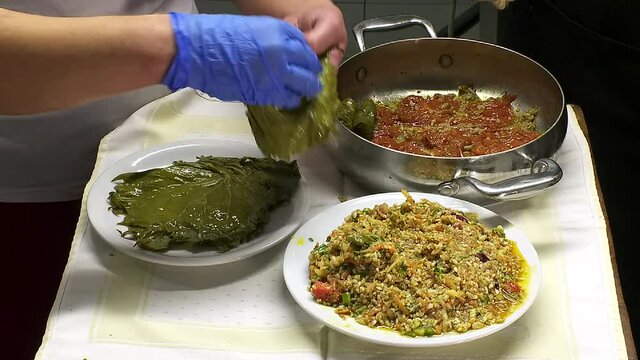 Rhodes Greece: preparing to Cooke dolmadakia or sarmadakia a traditional Greek plate made by staffed vine leaves with mainly rise 