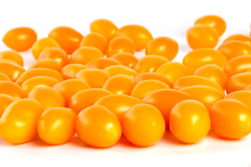 multiple yellow cherry tomatoes on a white background with shadow