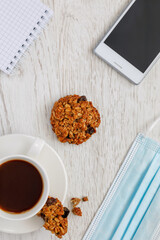 Background with coffee and cookies, mask, top view, vertical photo