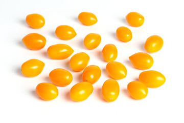 multiple yellow cherry tomatoes on a white background with shadow