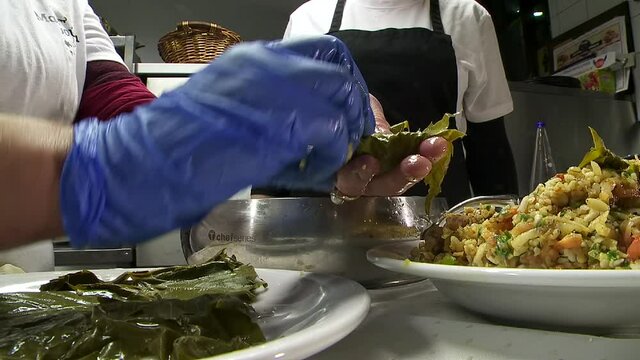 Rhodes Greece: preparing to Cooke dolmadakia or sarmadakia a traditional Greek plate made by staffed vine leaves with mainly rise 