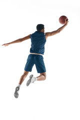 High flight. Young arabian muscular basketball player in action, motion isolated on white background. Concept of sport, movement, energy and dynamic, healthy lifestyle. Training, practicing.