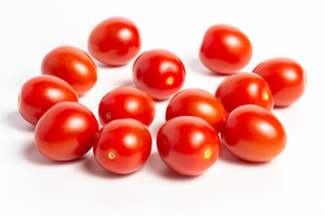 a few tomatoes on a white background with a shadow.