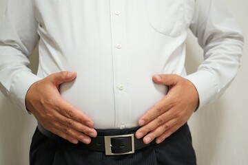 Overweight businessman body with hands touching belly fat - お腹の出ているビジネスマン