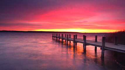 Fototapeta na wymiar blutroter Sonnenaufgang am See