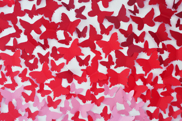 red paper butterflies. Cut-out paper figure of a butterfly on the wall
