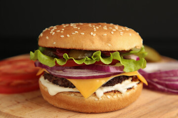 Fresh tasty burger and ingredients on a dark background.