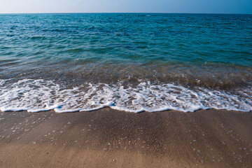 Seascape. Waves running on the sandy shore. Shore of the sea or ocean on a nice day. Vacation and relaxation by the sea.