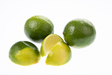 whole limes and lime wedges isolated on white