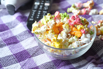high angle view of popcorn and Tv remote on table 