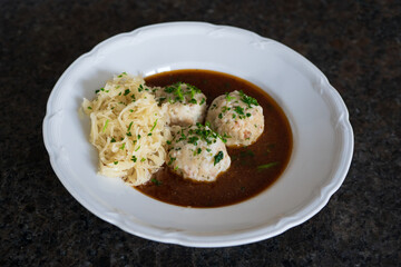 ready to eat, traditional bacon dumplings with pickled cabbage and brown sauce