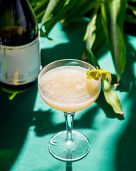 yellow tropical cocktail on a background of foliage, shadows from the sun. Green background