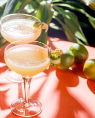 yellow tropical cocktail on a background of foliage and shadows from sunlight