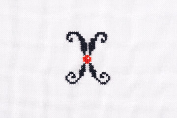 Letter X of Embroidered Cross - Stitch Latin Alphabet on White Linen Fabric Handmade Close-up