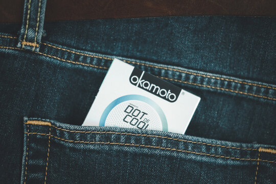 Samut Prakan, Thailand - February 2, 2021 : Okamoto condoms in jean pocket. Japanese made condom represent.