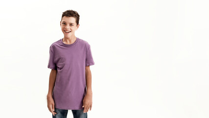 Happy teenaged disabled boy with cerebral palsy smiling at camera while posing, standing isolated...