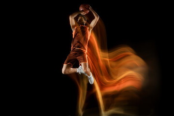 Slam dunk. Young arabian muscular basketball player in action, motion isolated on black background...