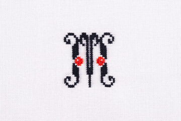 Letter M of Embroidered Cross - Stitch Latin Alphabet on White Linen Fabric Handmade Close-up