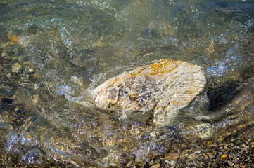 pebble stones on the sea beach, the rolling waves of the sea with foam