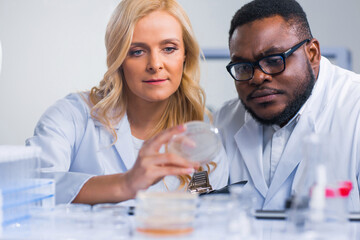 Professional team of scientists is working on a vaccine in a modern scientific research laboratory. Genetic engineer workplace. Future technology and science.